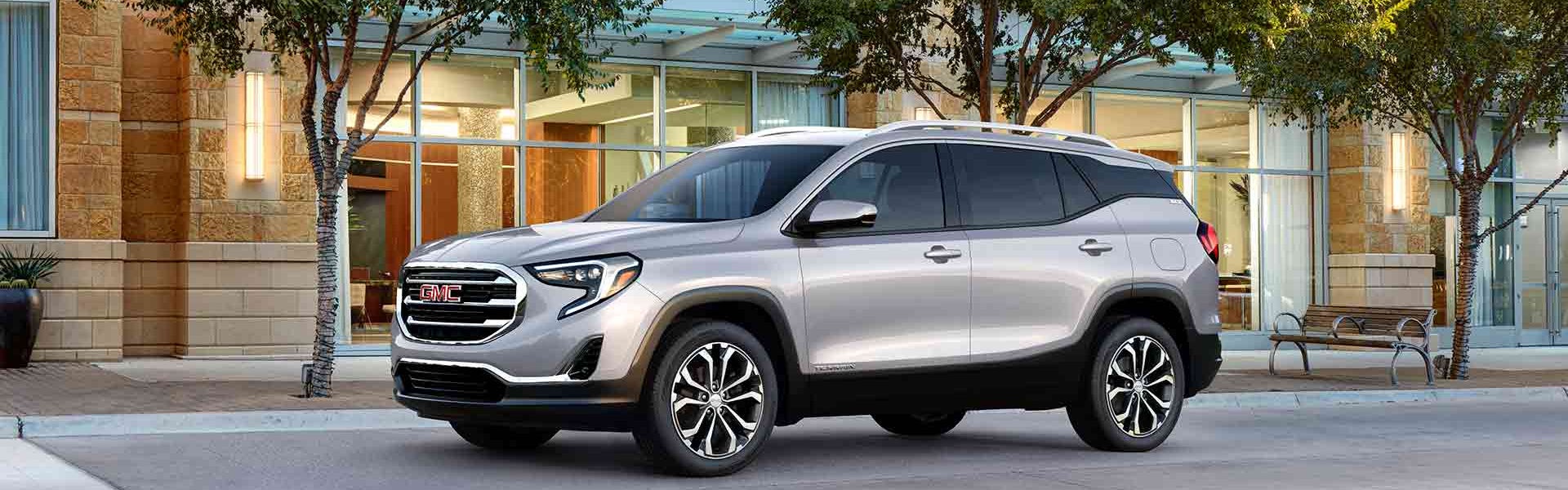 Silver GMC Terrain parked outside of a office building